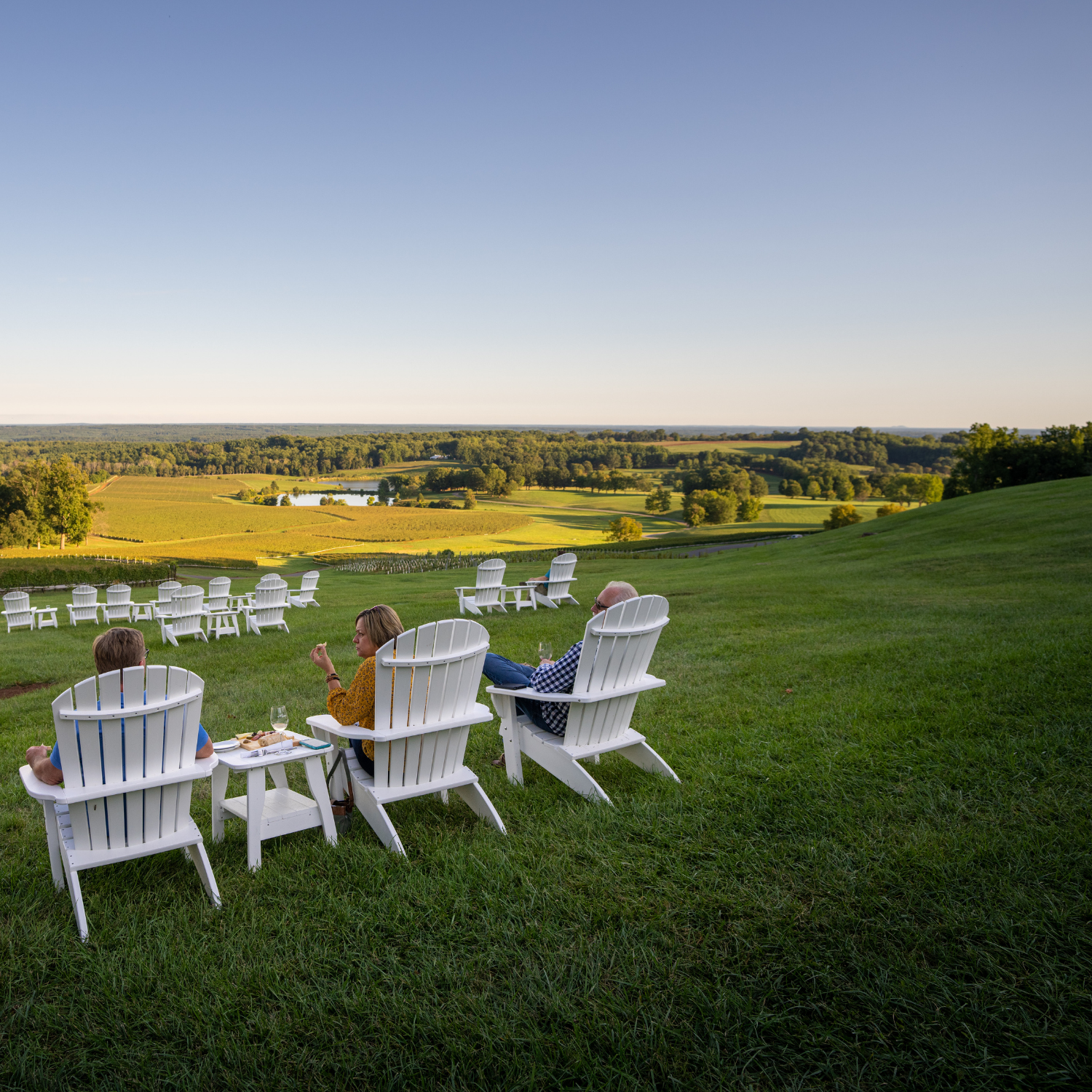 Couple enjoying charcuterie and wine on Adirondack chairs