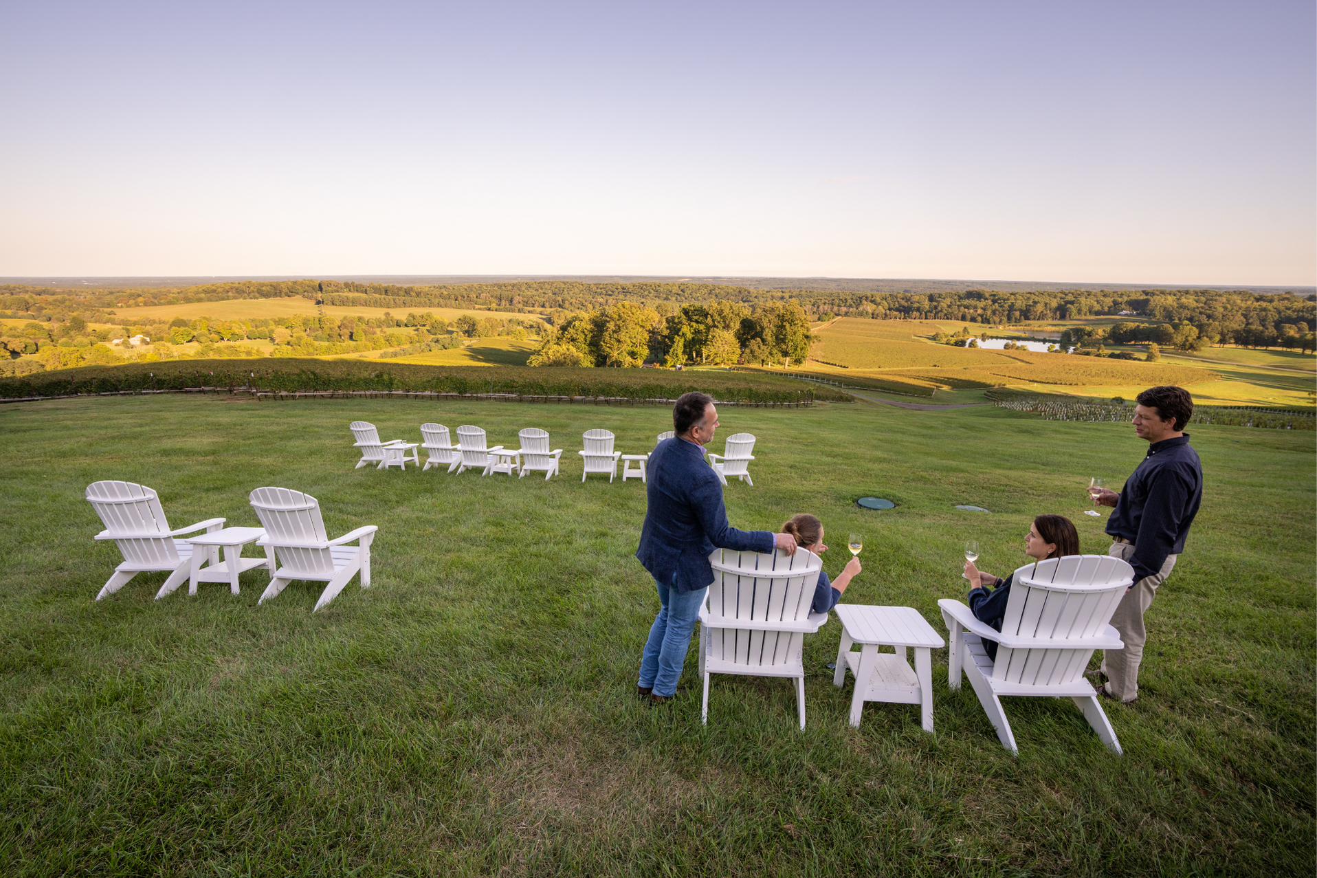 Couples enjoying wine on Adirondack chairs